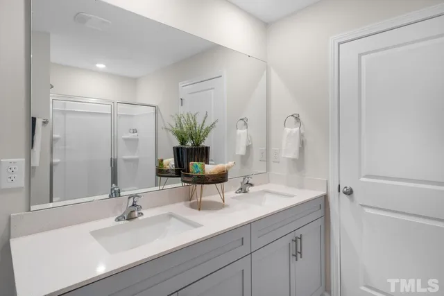 a bathroom with double vanity sink and a mirror