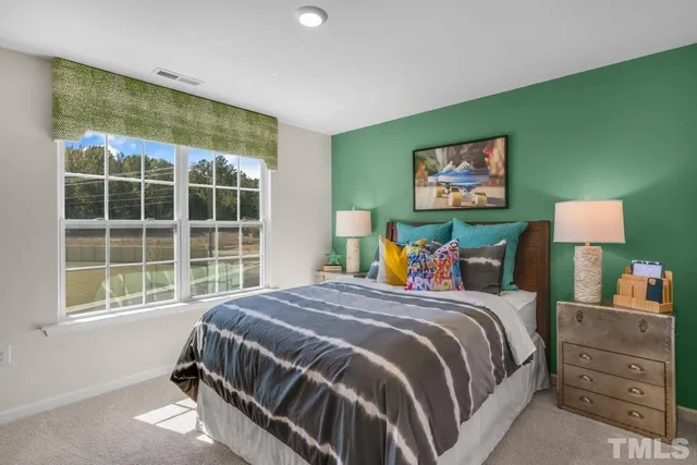 a bed sitting in a bedroom next to a window