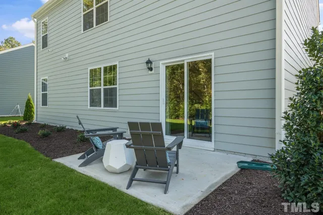 a view of a chair and table in backyard of the house