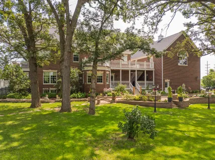 a front view of a house with swimming pool and garden