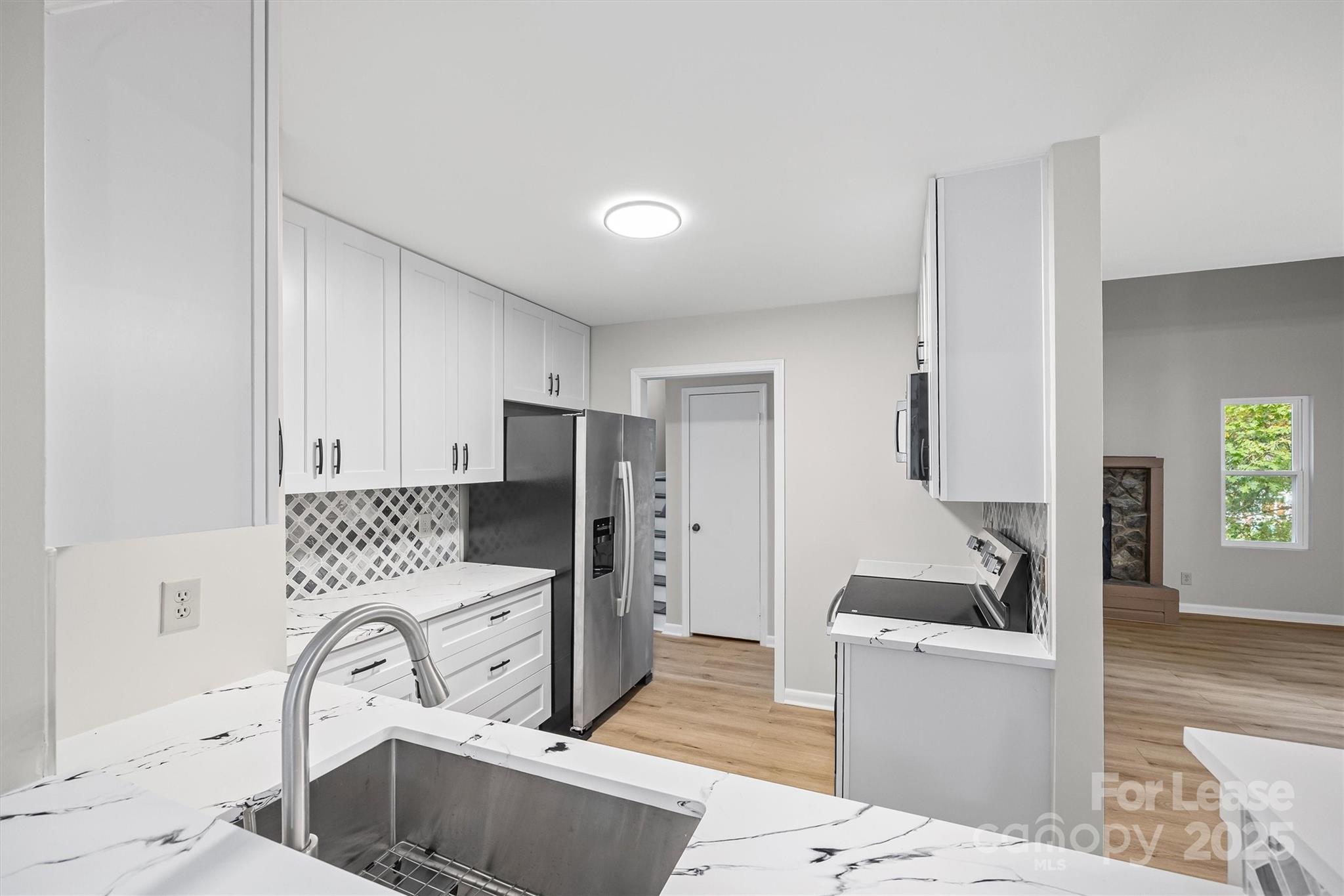 6012 Lanai Lane Fort Mill, SC 29708 - Photo 13 of 32 a kitchen with stainless steel appliances a sink a stove a refrigerator cabinets and a dining table