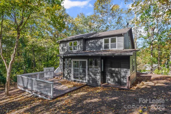 a view of a house with a small deck and a floor to ceiling window