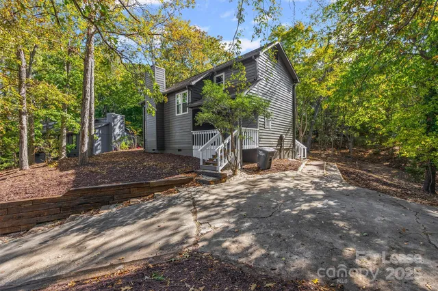 a view of a house with backyard and trees