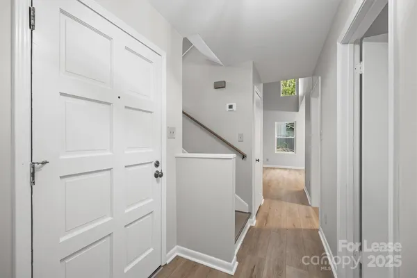 a view of a hallway with white walls and stairs