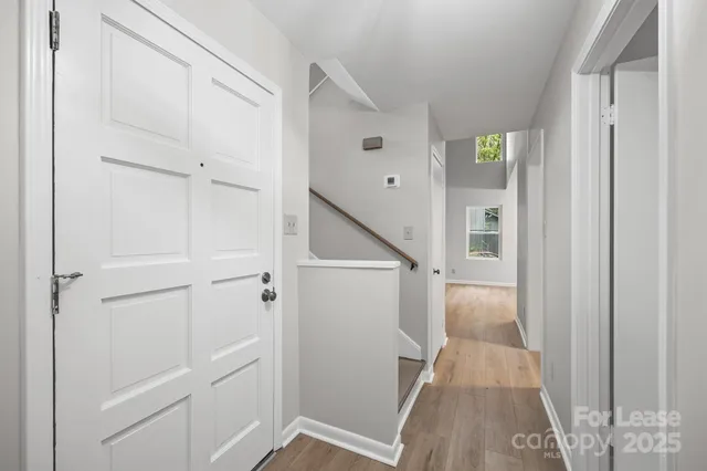 a view of a hallway with white walls and stairs