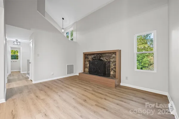 a view of an empty room with a fireplace and a window