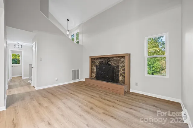 a view of an empty room with a fireplace and a window