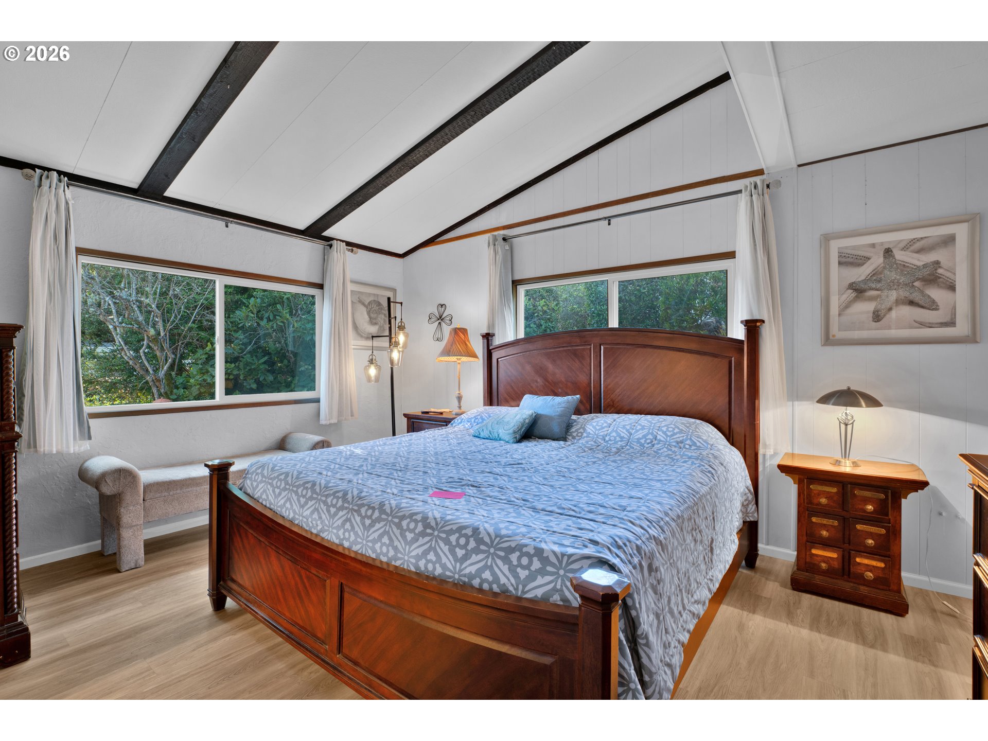 1601 Rhododendron Drive, Unit 534 Florence, OR 97439 - Photo 21 of 48 a bedroom with a bed a table and large windows