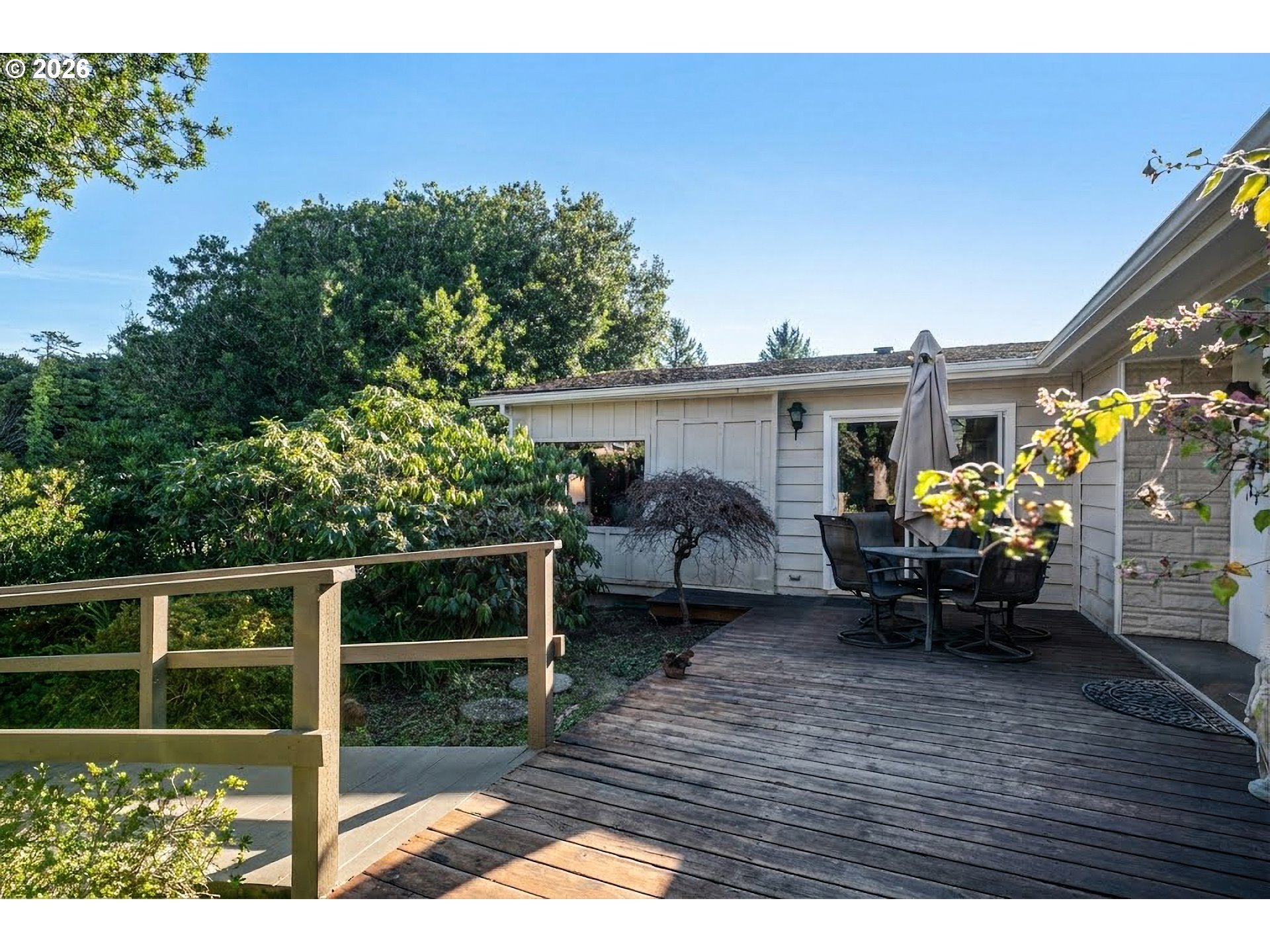 1601 Rhododendron Drive, Unit 534 Florence, OR 97439 - Photo 42 of 48 a view of a patio with table and chairs with wooden floor and fence