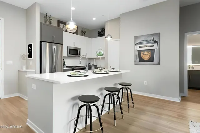 a kitchen with kitchen island a dining table and chairs