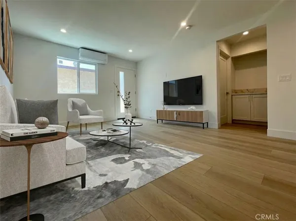 a view of a kitchen with wooden floor and electronic appliances