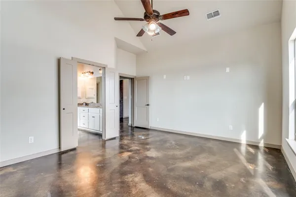 an empty room with closet and a ceiling fan