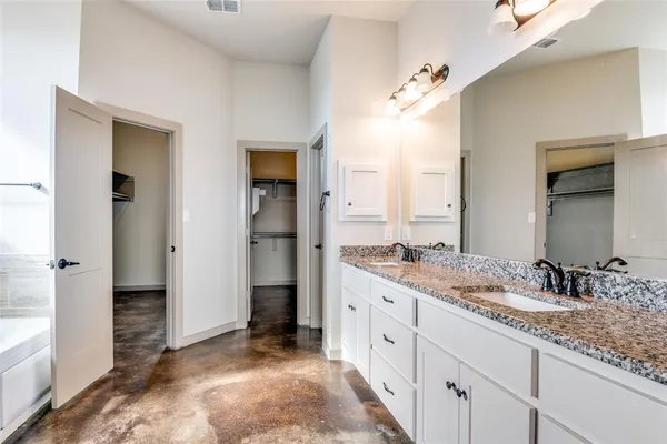 a spacious bathroom with a granite countertop sink and a mirror