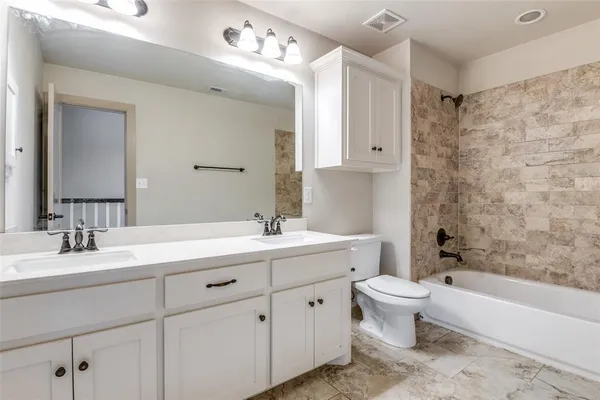 a bathroom with a double vanity sink toilet mirror and bathtub