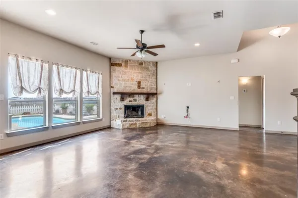 a view of an empty room with a fireplace and a window