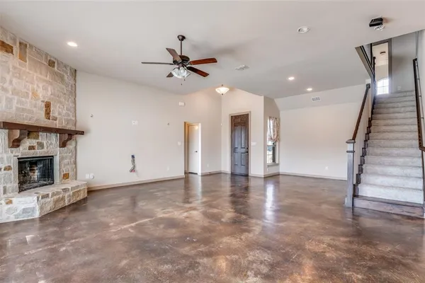 a view of an empty room with fireplace and a window