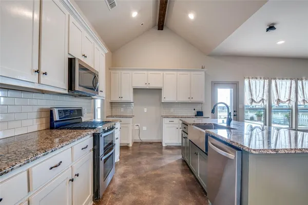 a kitchen with stainless steel appliances granite countertop a stove sink microwave and cabinets