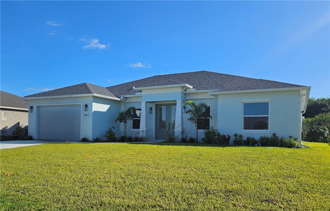 a view of a house with large windows and a yard