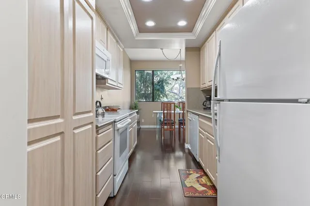 a kitchen with a refrigerator and white cabinets