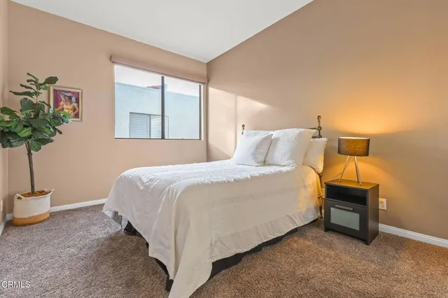 a bedroom with a bed and a potted plant