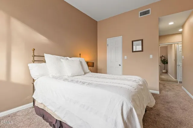 a bedroom with a bed and painting on the wall