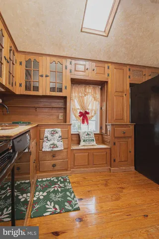 a living room with stainless steel appliances kitchen island granite countertop a refrigerator stove and oven with wooden floor