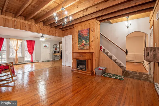 a view of a livingroom with wooden floor and a fireplace