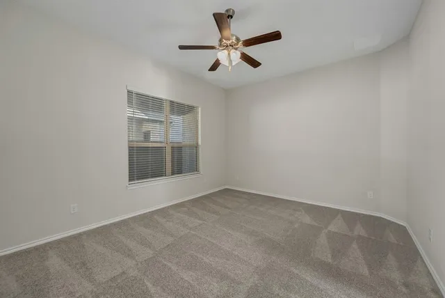 an empty room with closet and a ceiling fan