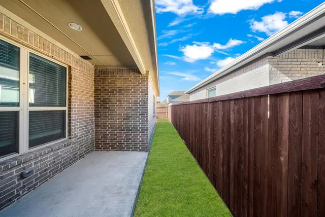 a view of a backyard with a fence and wooden fence