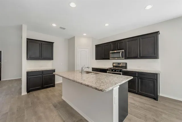 a kitchen with granite countertop stainless steel appliances and wooden cabinets