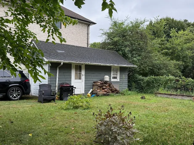 a view of a house with yard and sitting area