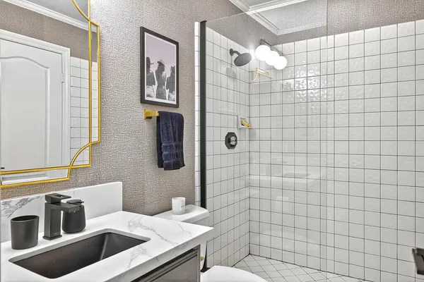 a bathroom with a sink a toilet and shower