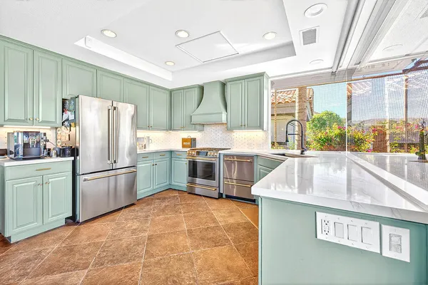 a kitchen with stainless steel appliances a refrigerator sink and cabinets