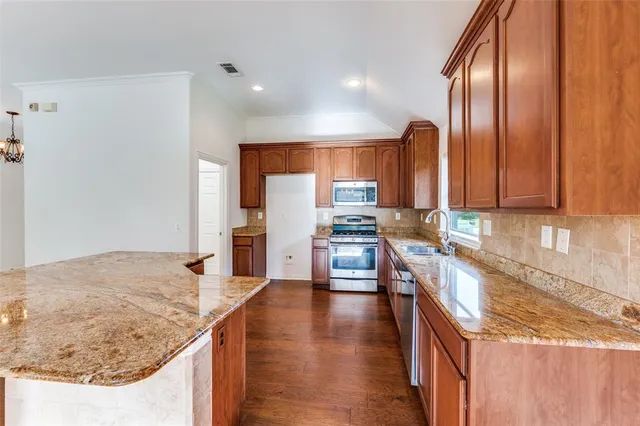 a kitchen with stainless steel appliances granite countertop a sink stove and refrigerator