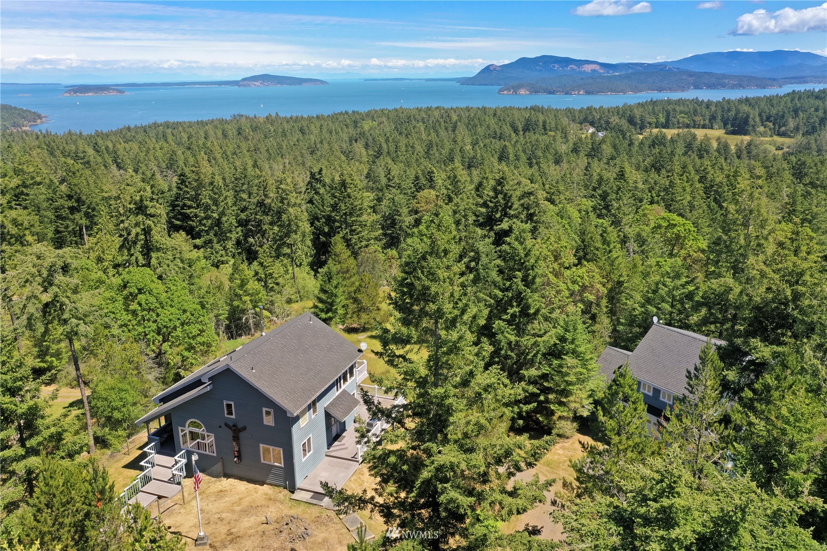 a view of a house with a yard and mountain view in back