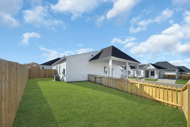 a view of a house with a big yard and large trees