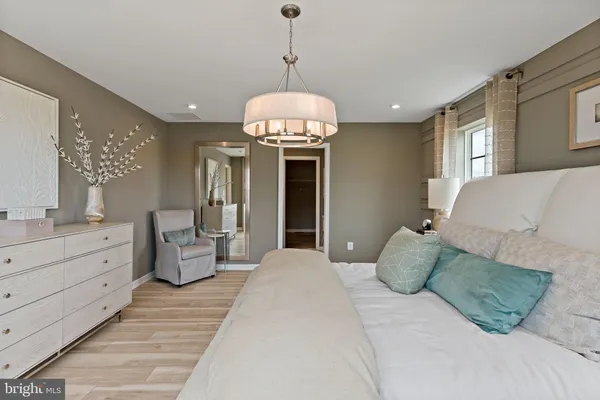 a spacious bedroom with a large bed and a chandelier