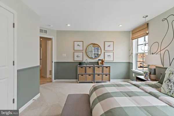 a bedroom with a bed a chandelier and a dresser