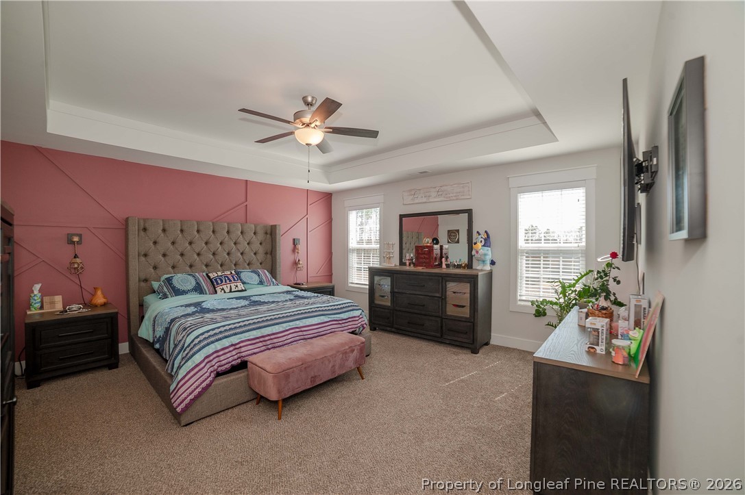 1537 Creekwood Road Hope Mills, NC 28348 - Photo 20 of 41 a bedroom with a bed potted plant on dresser and a chandelier