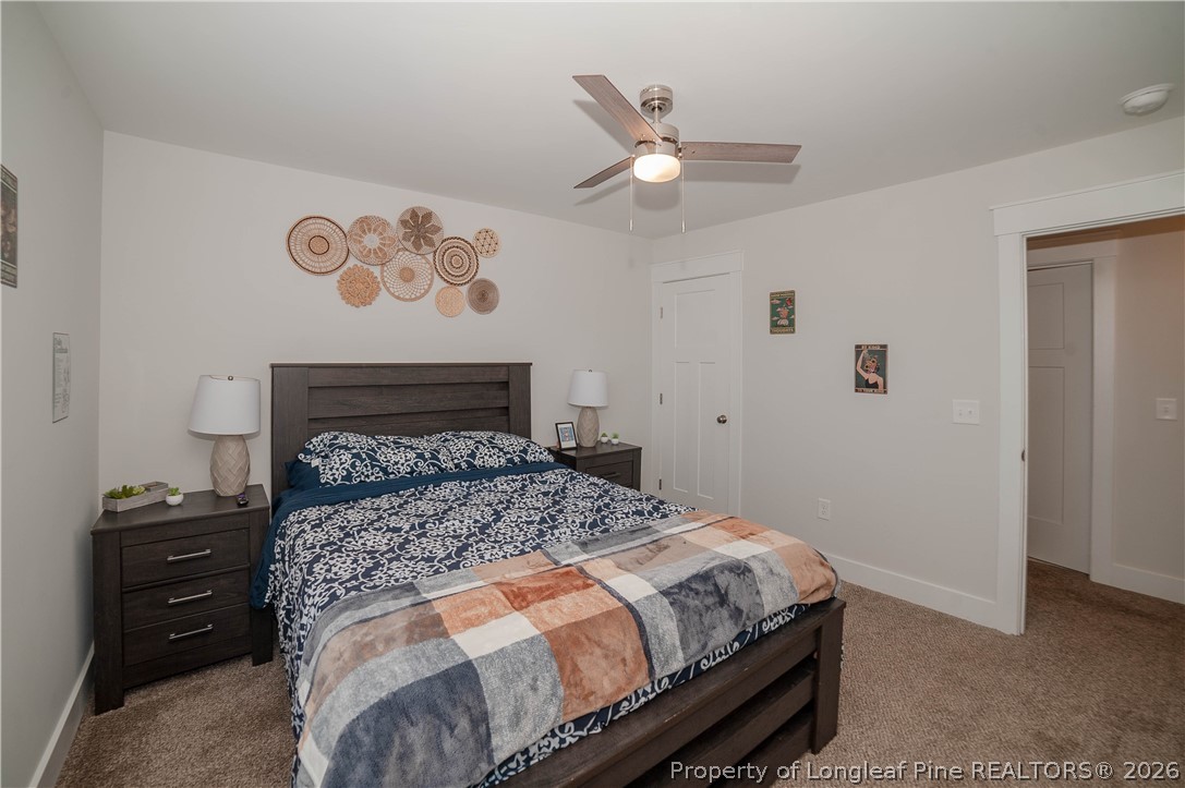 1537 Creekwood Road Hope Mills, NC 28348 - Photo 32 of 41 a bedroom with a bed and a lamp on the dresser