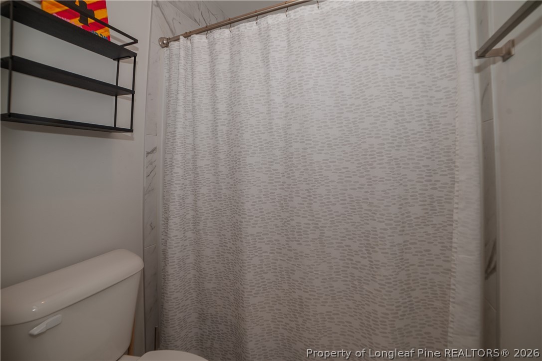 1537 Creekwood Road Hope Mills, NC 28348 - Photo 36 of 41 a bathroom with a shower curtain and a toilet