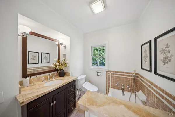 a spacious bathroom with a granite countertop sink a toilet a mirror and shower