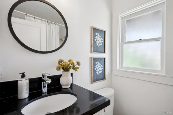 a bathroom with a toilet a sink and a mirror