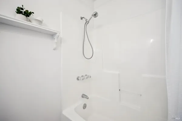 a bathroom with a bath tub with a shower