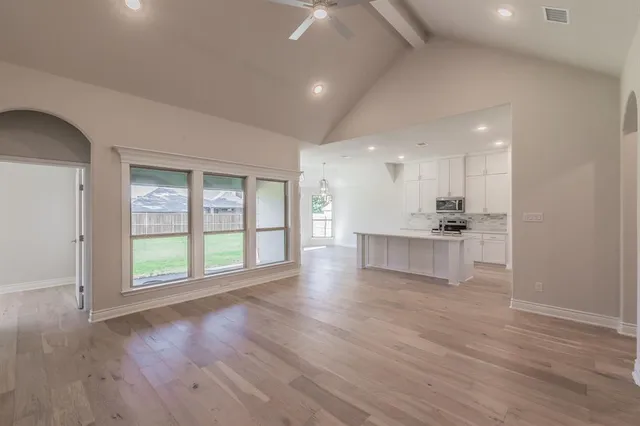 a view of kitchen with stainless steel appliances refrigerator stove and wooden floor