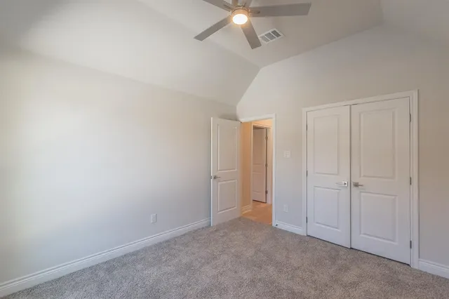an empty room with a ceiling fan and closet area