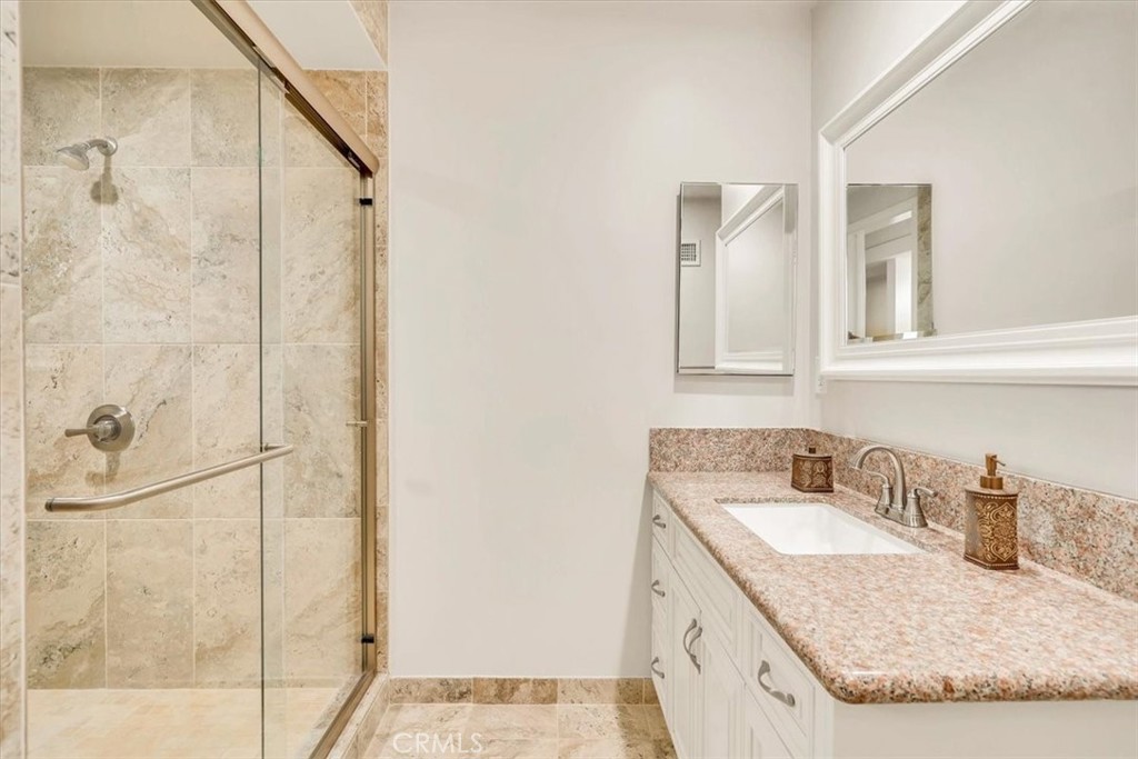 2355 Montecito Drive San Marino, CA 91108 - Photo 19 of 47 a bathroom with a granite countertop sink a mirror and shower