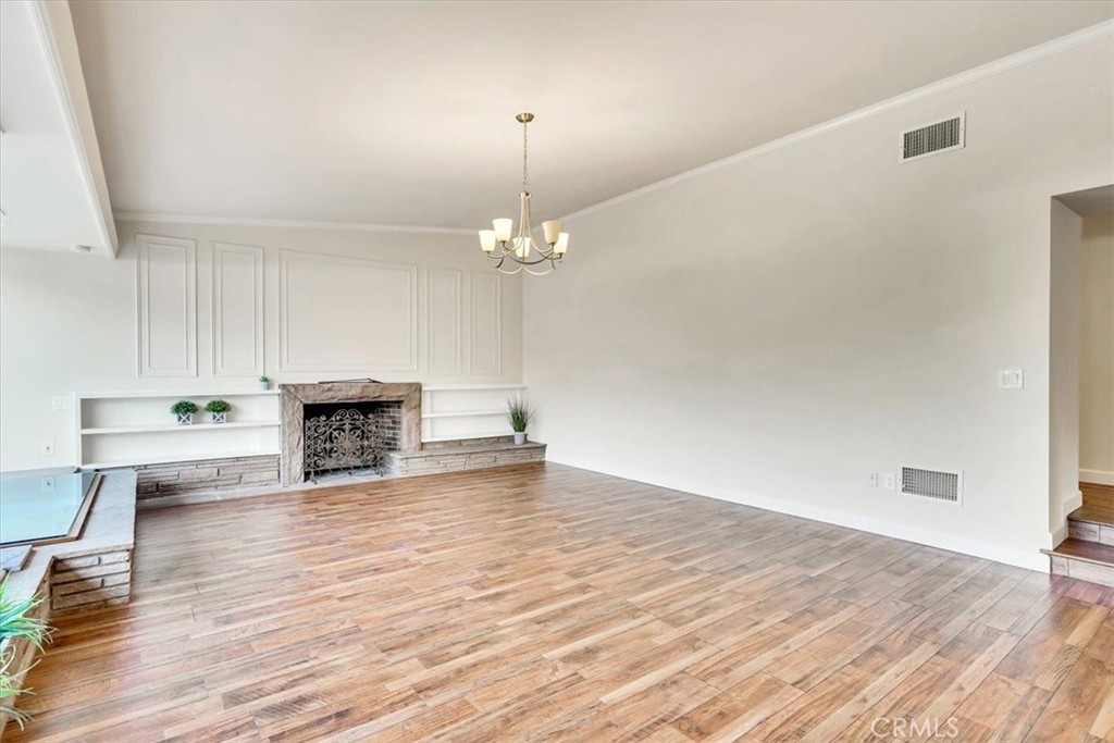 2355 Montecito Drive San Marino, CA 91108 - Photo 7 of 47 a view of an empty room with wooden floor and a fireplace