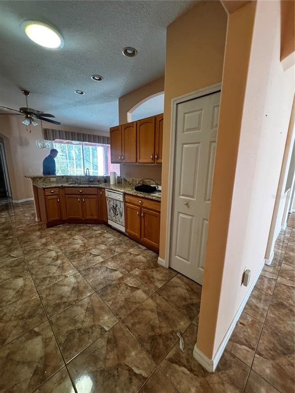 15296 Southwest 15th Terrace Road Ocala, FL 34473 - Photo 13 of 15 a kitchen with granite countertop a refrigerator and wooden cabinets