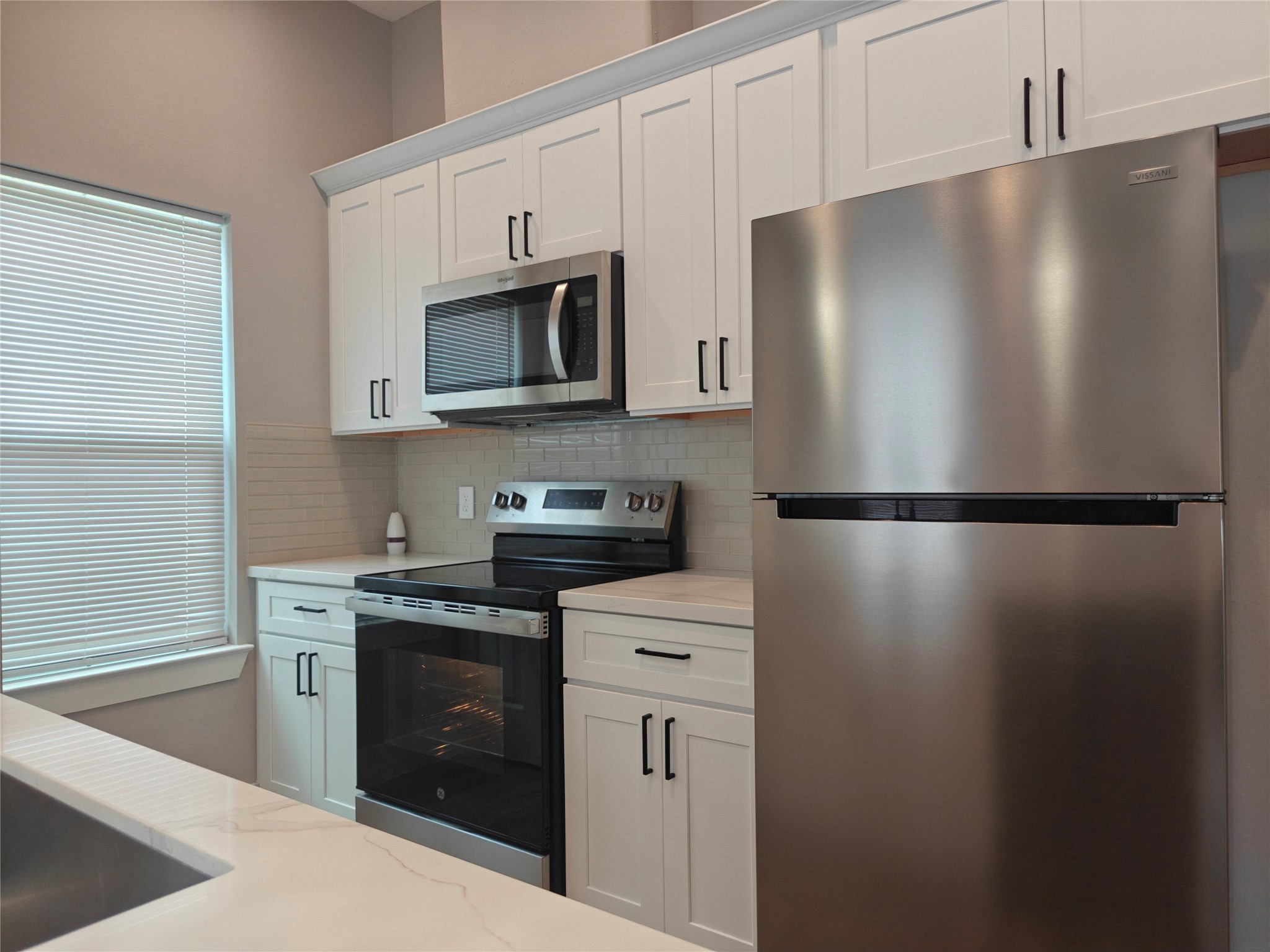 4124 Vaughn Street, Unit B Houston, TX 77016 - Photo 6 of 19 a kitchen with stainless steel appliances a refrigerator sink and microwave